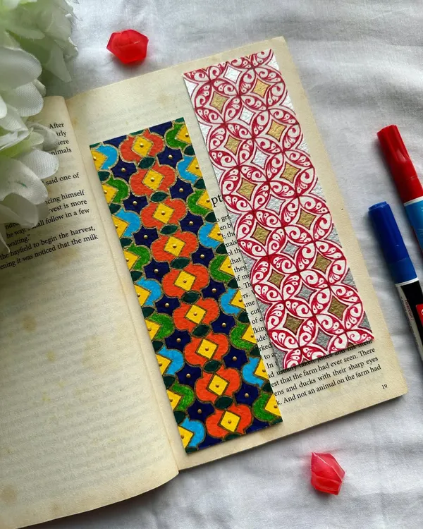 A pair of vibrant, handmade bookmarks featuring intricate geometric patterns. The one on the left has a colorful floral-inspired design, while the one on the right uses a classic red and gold combination. Custom orders are always welcome.