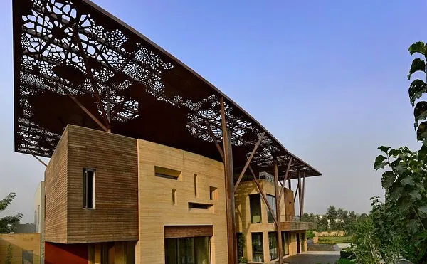 The Tree House's most striking feature is its expansive, perforated metal roof, supported by columns that branch out like trees. This canopy not only defines the home's aesthetic but also functions as a climate control element, shading the structure from the harsh sun.