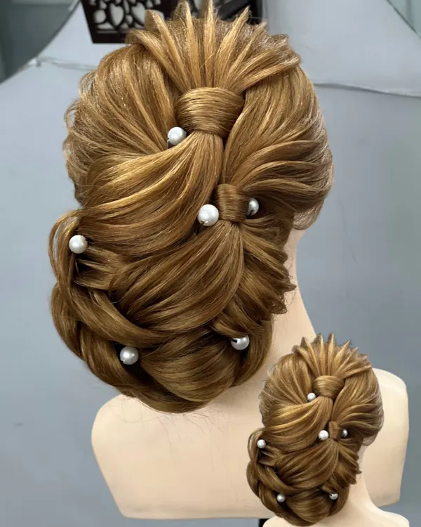 A clear, detailed look at an advanced bridal bun. We practice these styles on mannequins until you get the technique just right.