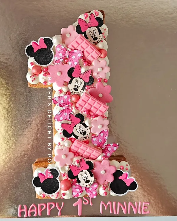 One in a Minnie! This number "1" shaped tart cake was a magical way to celebrate a first birthday. The butter tart base is filled with chocolate mousse and decorated with adorable Minnie Mouse details.