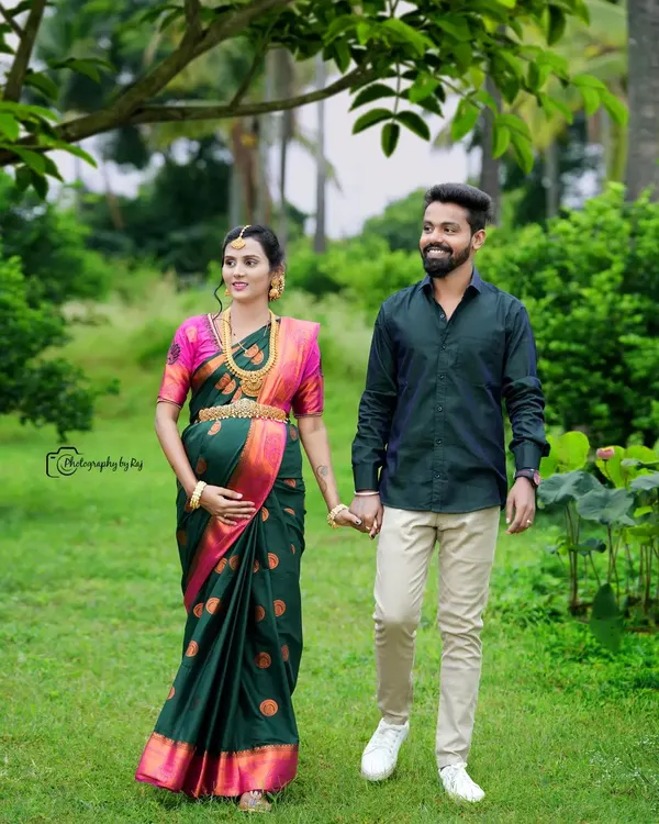 A beautiful couple's portrait taken during a walk in our garden. The mother-to-be looks stunning in a dark green and pink silk saree, complemented by traditional gold jewelry.