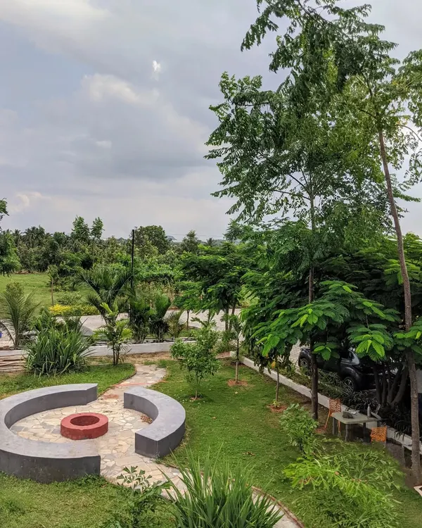 An overhead view of a spacious garden featuring a custom-built circular fire pit and seating area. This design creates a natural gathering spot within the larger landscape for friends and family.