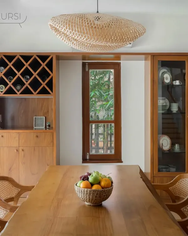 This dining room, designed by a collaborator, features my live-edge teak dining table and rattan chairs. The space is completed with a custom teak bar and crockery unit, creating a warm and inviting area for meals.