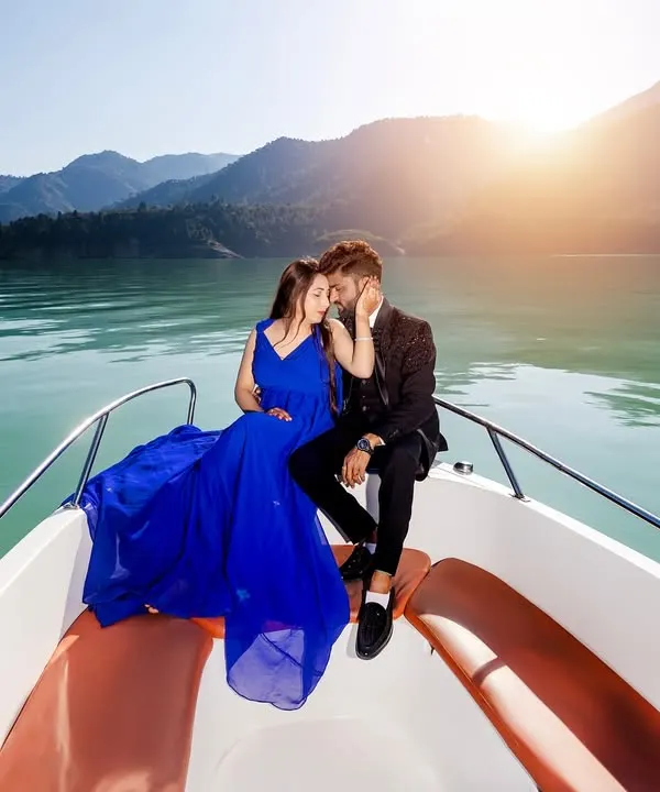 An intimate moment on a speedboat at Tehri Lake. The golden hour sunlight and the vibrant blue of the dress against the water create a truly magical and romantic pre-wedding photograph.