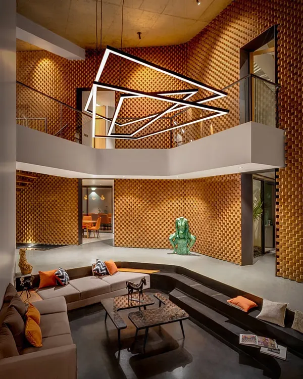 This is the double-height living space of our Sun House project. We used textured brickwork flowing from exterior to interior to create a dramatic, monolithic feel, while the sunken amphitheater-style seating establishes an intimate, grounded area for conversation, demonstrating our belief that space can be both grand and personal.