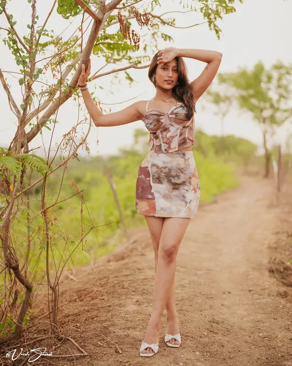 This full-length pose from an outdoor portfolio shoot shows how we can use natural elements like trees and pathways to frame the shot. It's a great way to add context and style to your modeling book.