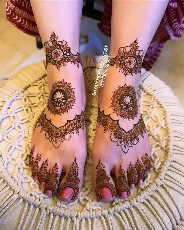 Elegant and symmetrical foot mehandi featuring a central lotus mandala and delicate floral details.