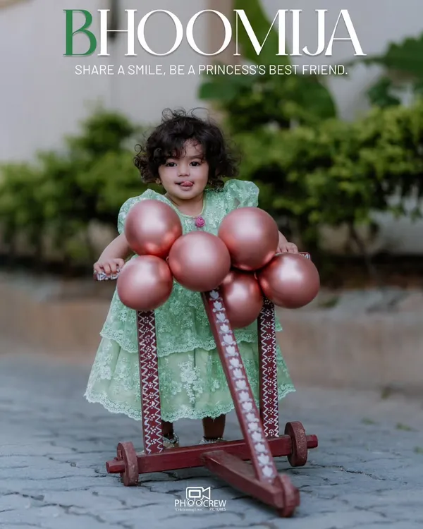 A beautiful outdoor portrait for a first birthday. Little Bhoomija looks like a princess in her lovely green dress, posing with a cute wooden walker decorated with balloons, perfectly capturing the sweetness of turning one.