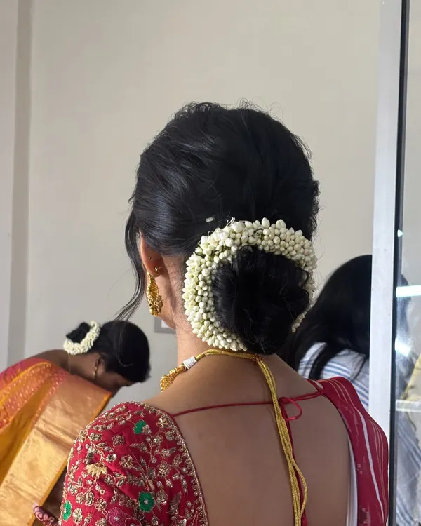 This classic low bun is adorned with a beautiful jasmine gajra, a staple for traditional South Indian bridal hairstyles. I teach the technique for creating a smooth, secure base that holds fresh flowers perfectly.