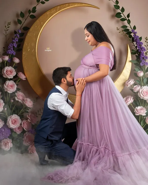 A truly romantic moment. The father-to-be kisses the baby bump in our celestial-themed setup, complete with a golden moon and a bed of clouds.