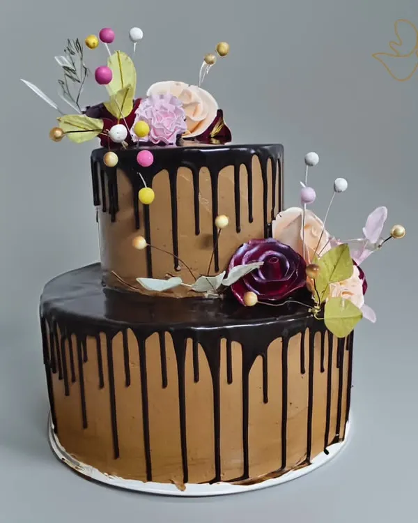 This two-tier chocolate drip cake is a true showstopper, perfect for any celebration like a baby shower or anniversary. The rich chocolate frosting and elegant floral decorations make it as beautiful as it is delicious.
