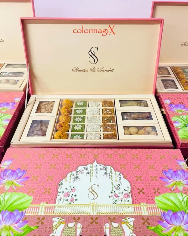 Our vibrant pink wedding hamper, personalized with the couple's monogram, is a testament to bespoke luxury. This grand box is filled with an assortment of traditional sweets and premium dry fruits, making it a perfect announcement gift or a memorable wedding favor.