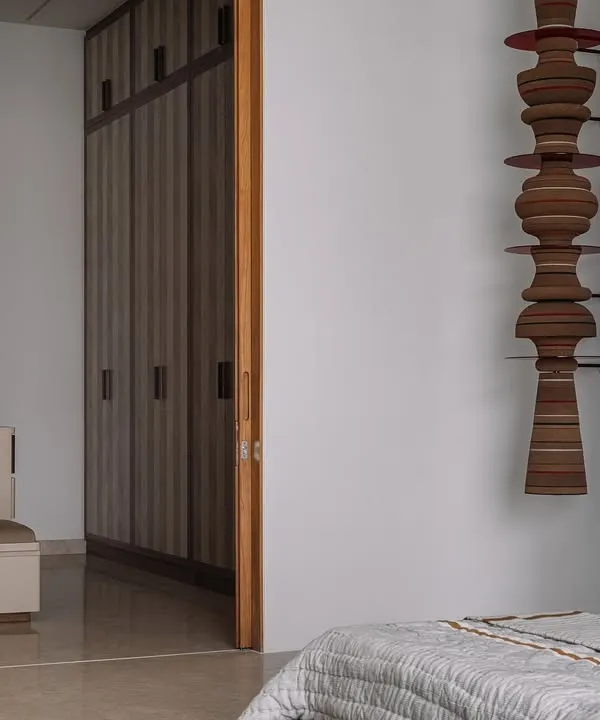 This is the parents' suite at our Rehethaan project. The family room is defined by a serene palette of ivories and ochres, with custom-designed sofas and a patterned chaise lounge creating a comfortable and elegant living space.