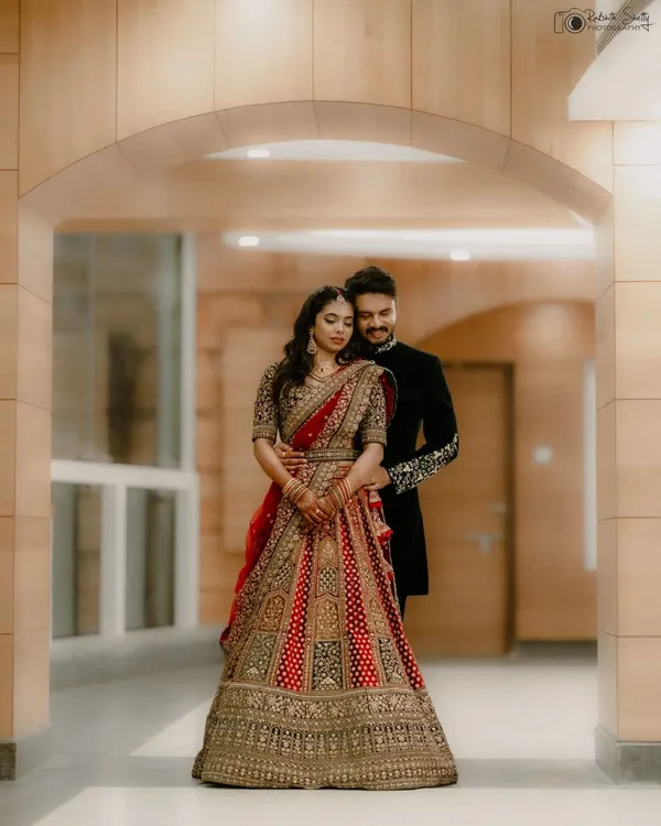 Framed by the architecture, this portrait feels like a classic painting. The couple's elegant reception attire and the intimate pose create a sense of timeless romance, a perfect memory of their wedding day.