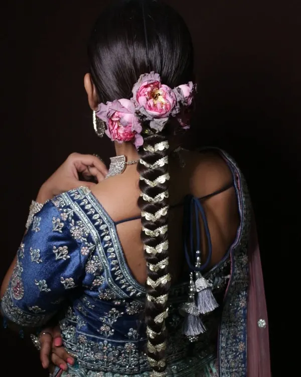 A stunning example of a traditional bridal braid, intricately woven with gota patti and adorned with fresh flowers. This is a key style covered in my advanced hairstyling course.