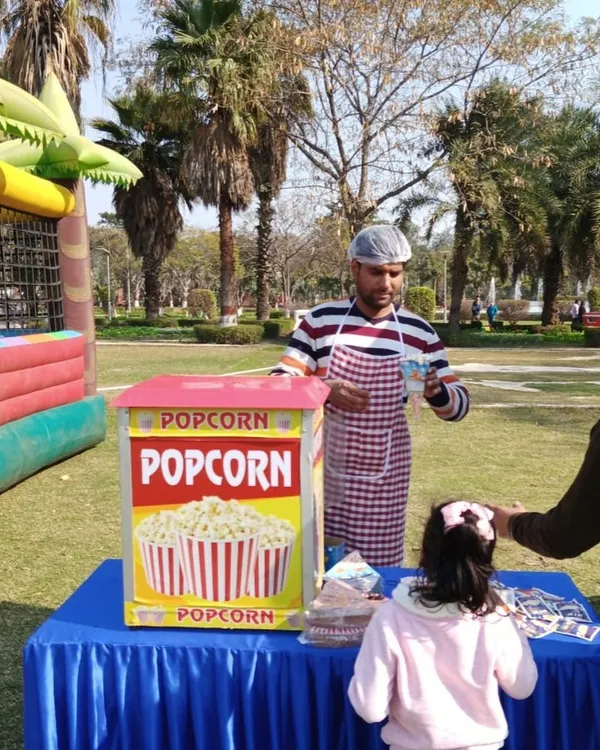 A popcorn machine on rent for a family day event. My operator serves fresh, hot popcorn to guests, adding a classic carnival feel to the celebration.