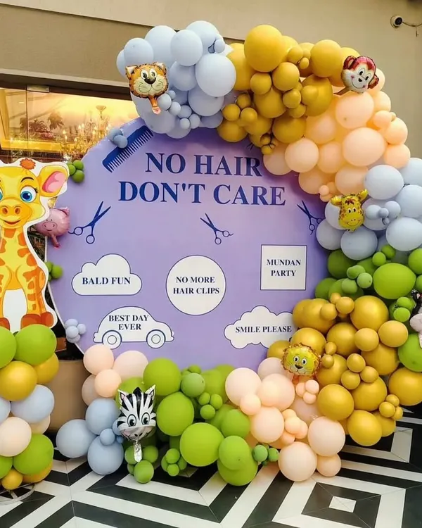 A fun and playful "No Hair Don't Care" theme for a Mundan ceremony. This setup features a custom backdrop, a vibrant pastel balloon arch, and adorable jungle animal cutouts like a giraffe and zebra.