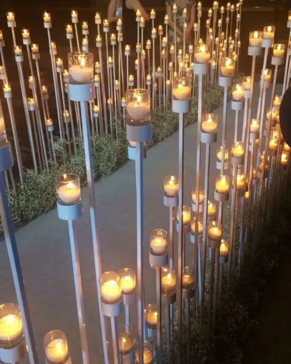 A beautiful pathway lined with dozens of candles at varying heights. This creates a magical, romantic, and dramatic entrance for an evening or night event.