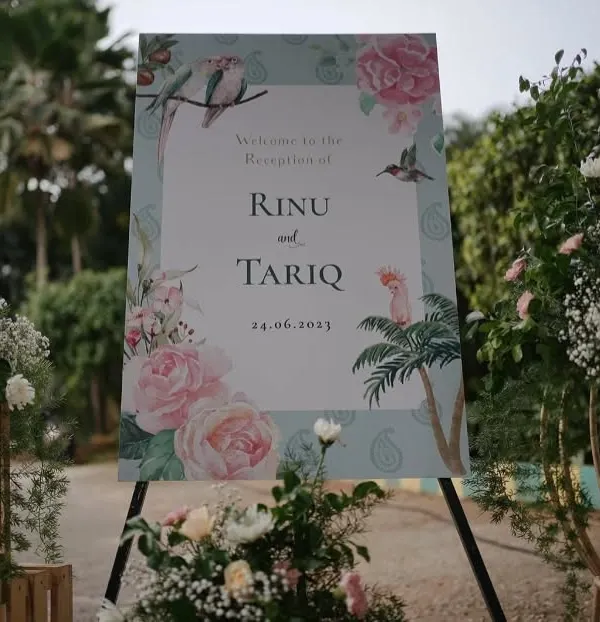 A beautifully designed welcome sign for a reception, featuring a custom illustration of the couple's names, date, and delicate floral artwork that matches the event's theme.