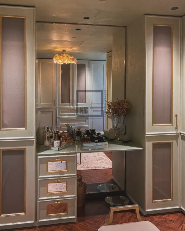 Here is a closer look at the built-in vanity inside a custom walk-in closet. The large mirror reflects the entire space, making it feel bigger, while the gold-trimmed drawers and elegant countertop provide a dedicated, well-lit area for getting ready.