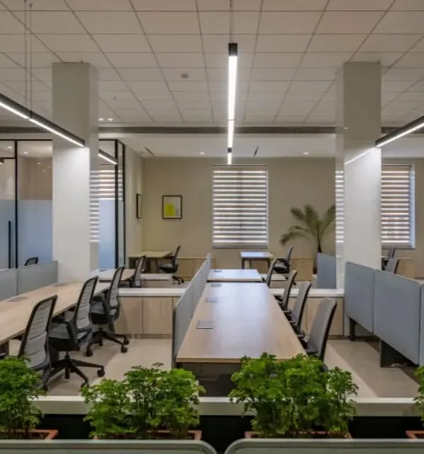 This open-plan office is designed for a modern workforce. We integrated planters into the workstation dividers to bring in nature, while the linear lighting and clean desk layouts create a sense of order and professionalism.