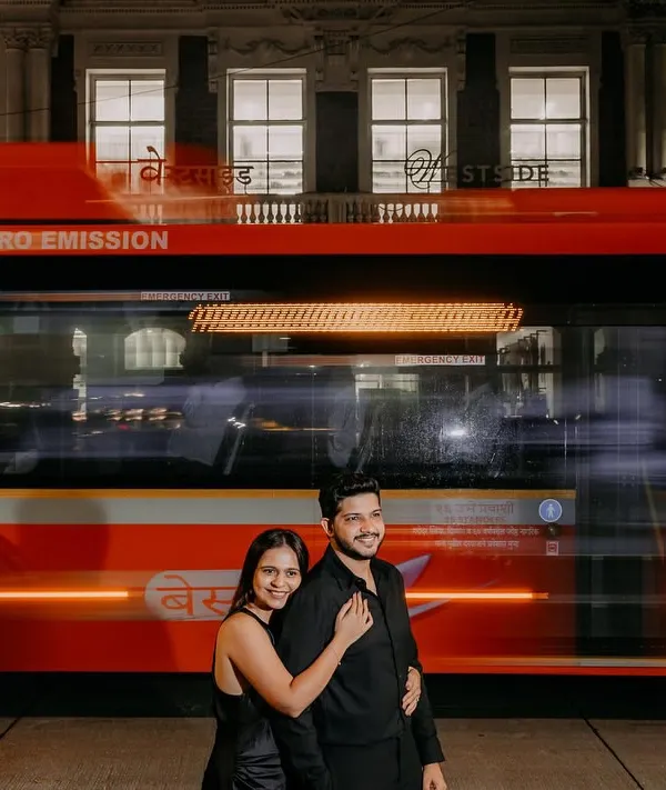 A couple shares a quiet moment as the vibrant energy of a Mumbai BEST bus streaks past. I used a slow shutter speed for this pre-wedding photograph to create a cinematic effect, freezing their connection amidst the city's constant motion.