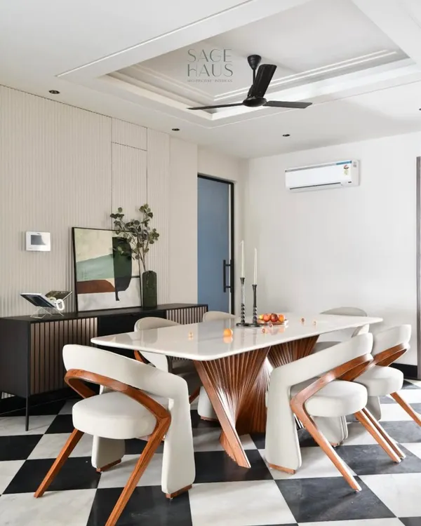 This dining space is a study in contrasts, designed to spark conversation. The sculptural base of the table, the gentle curves of the chairs, and the bold, graphic statement of the checkerboard floor come together to create a room with minimal yet dramatic presence.
