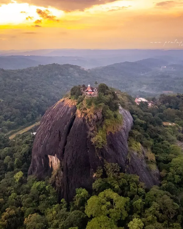 An aerial view of an ancient Shiva temple perched atop a massive rock monolith in South Canara. This shot combines the thrill of drone photography with the deep-rooted history of our land, telling a story of faith and nature intertwined. The sunset colours add a layer of divine glow to the scene.