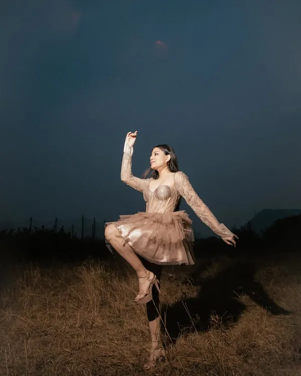 An outdoor high-fashion shoot where the outfit becomes part of the landscape. The dramatic lighting and pose create a surreal, artistic image perfect for a designer lookbook or brand campaign.
