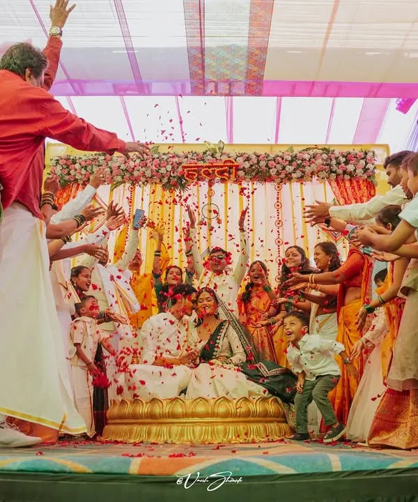 The Haldi ceremony at its most chaotic and joyful, with family and friends showering the couple with flower petals.