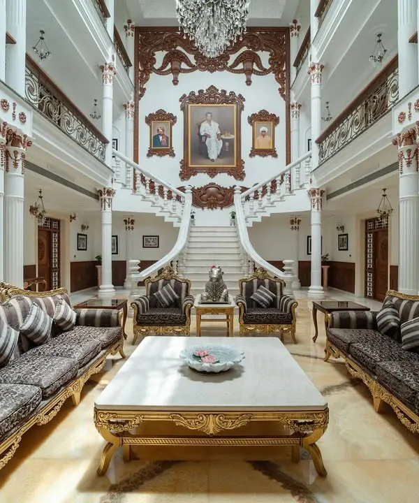 The living area of "The Palace Promised" is designed on a scale that inspires awe. This view from the grand staircase showcases the triple-height volume, the intricate woodwork, and the opulent furniture that together create a space of pure magnificence.
