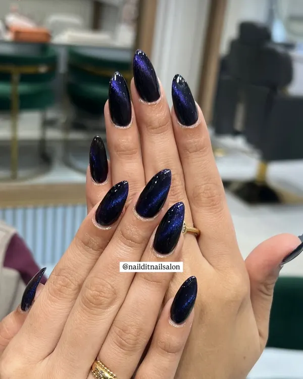 A perfect example of the cat-eye effect. We use magnetic polish to create a stunning blue and purple galactic shift on these long, almond-shaped nails.