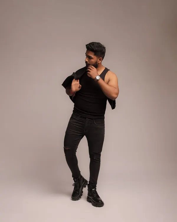 A full-length fashion-style portrait against a clean studio background. This type of image is perfect for building a fitness influencer's brand, showcasing style and presence along with a strong physique.