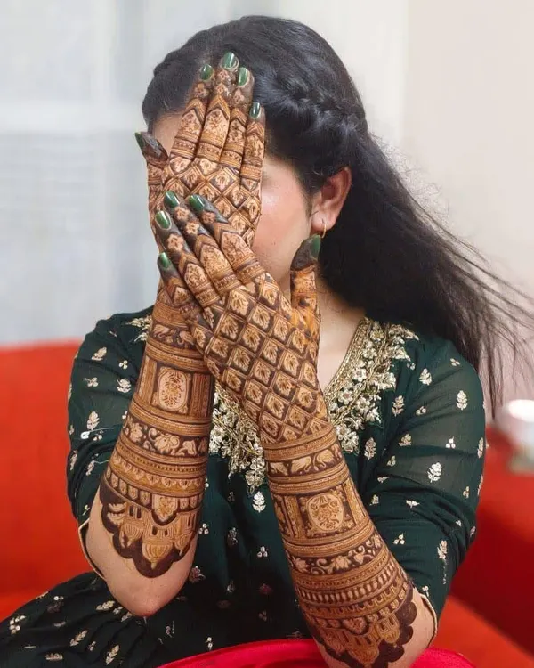 A classic full-hand bridal design with a heavy 'jaal' or net pattern. This style is timeless and gives a very rich, filled-in look that brides love.