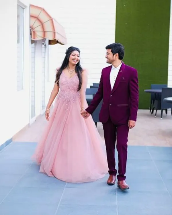 A perfect couple's look for a reception or engagement party. This flowing baby pink gown with delicate embroidery on the bodice pairs beautifully with a sharp wine-coloured tuxedo. Both are available to rent for your special day.
