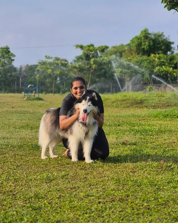 A happy owner and her beautiful Alaskan Malamute enjoying our spacious, sprinkler-cooled lawns. This is what true enrichment looks like.