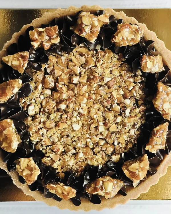 This is pure decadence. My dark chocolate and almond praline tart features a rich chocolate filling, piped chocolate swirls, and a generous topping of crunchy almond praline.