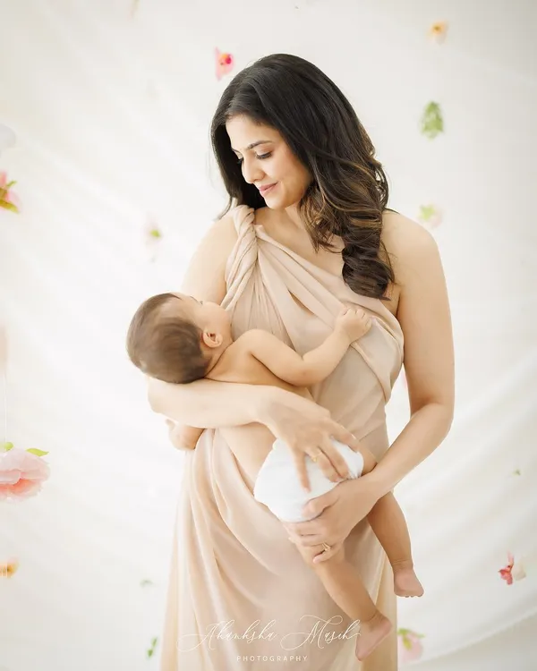 A mother's gentle gaze at her newborn. This portrait, with its soft light and ethereal floral background, feels like a painting of the purest love.