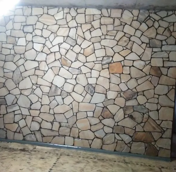 A full interior wall covered in light-colored, random-pattern stone cladding. This creates a stunning, rustic feature wall.