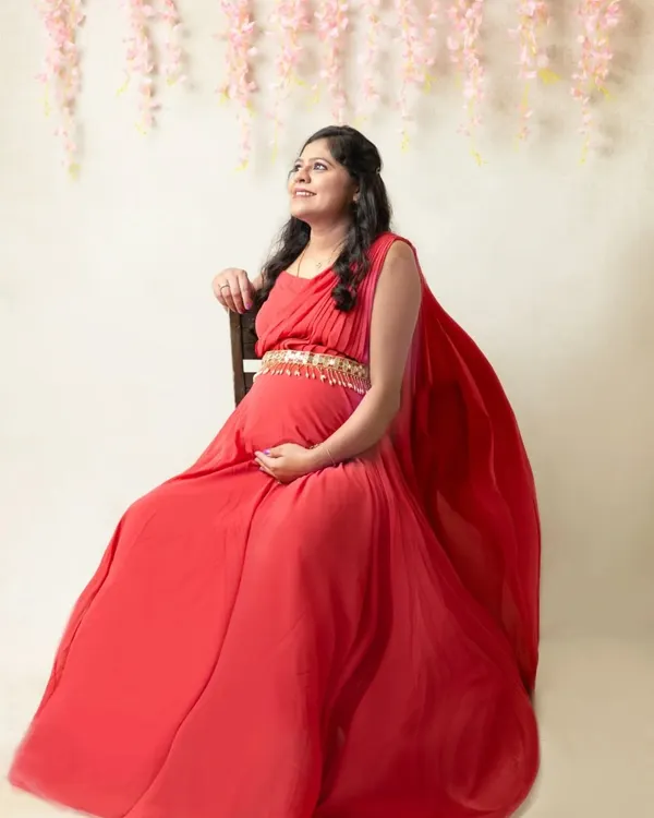 Feel like the queen you are in a flowing red gown. This dreamy maternity portrait uses soft light and a floral backdrop to highlight your radiant glow.
