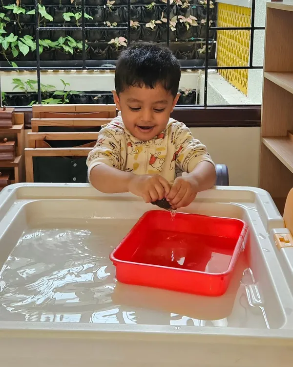 The simple joy of splashing in water. This child is exploring the properties of water while having fun, a core component of our sensory play philosophy.
