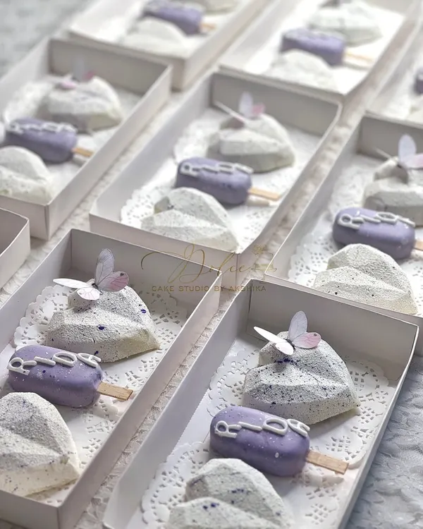 These are the return favor boxes I made for a lavender-themed event. Each box contains two geometric chocolate hearts and one personalized cakesicle, all resting on a delicate doily.