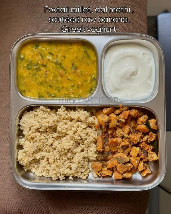 A perfectly balanced vegetarian meal featuring foxtail millet, dal methi (lentil and fenugreek curry), sautéed raw banana, and a side of Greek yogurt for a protein boost.