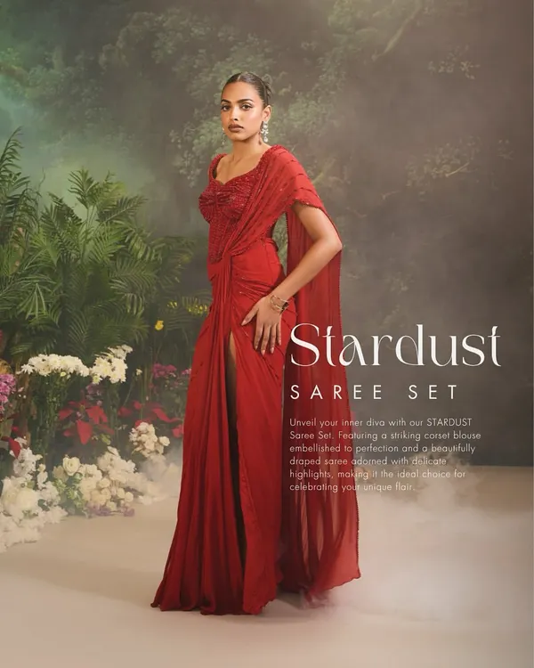 A full-length view of the Stardust Saree Set, showcasing its dramatic flow and elegant drape. The thigh-high slit adds a modern, confident touch to this classic red ensemble, perfect for cocktail parties and formal events.