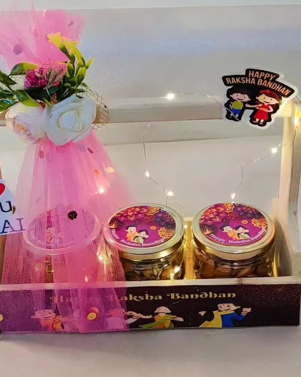 This beautifully lit wooden basket is a perfect Rakhi gift. It includes three jars for treats like cookies and muesli, a decorative floral bunch, and an "I Love You, Bhai" tag.