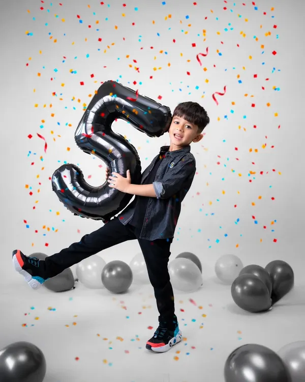Celebrating a milestone like turning five should be full of energy and joy. I designed this studio setup with bright confetti and balloons to match his vibrant personality. My goal is to capture the pure, unscripted happiness of the moment, creating a memory as lively as the celebration itself.