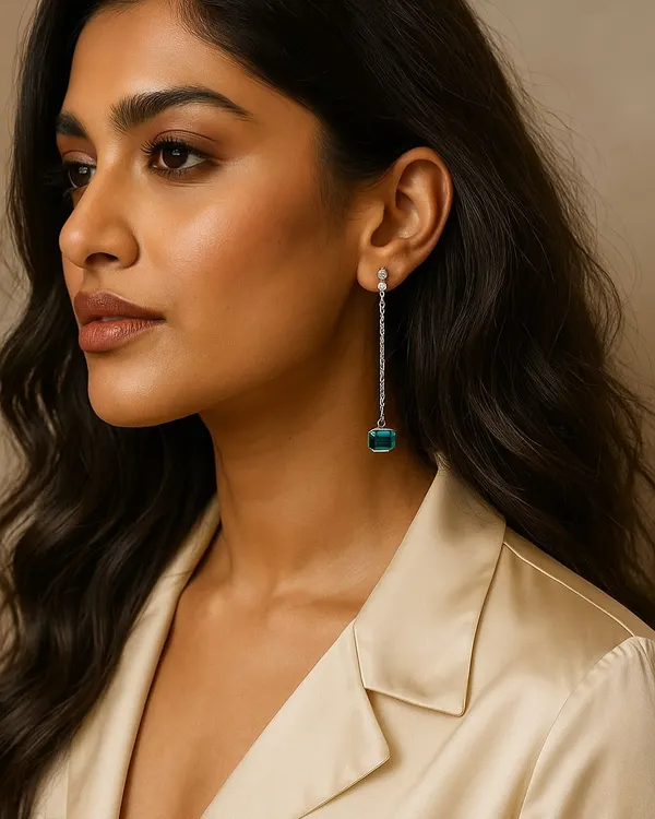Crafted for the woman who defines her own elegance. These long drop earrings feature a stunning square-cut green stone, suspended from a chain of sparkling diamonds. They are designed to speak without saying a word.