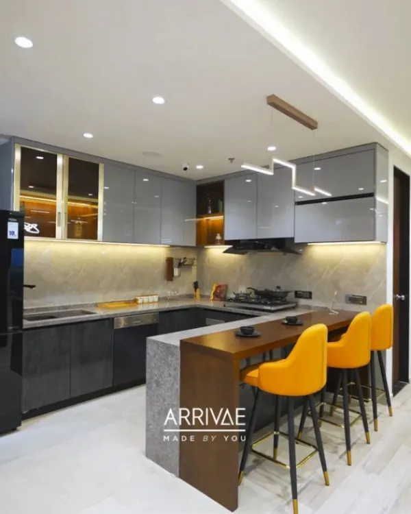 A stunning U-shaped modular kitchen featuring a sleek breakfast bar with vibrant yellow stools. This design combines glossy grey upper cabinets and dark textured lower units, all brought together with warm under-cabinet lighting and a modern pendant light, creating a perfect space for both cooking and socializing.