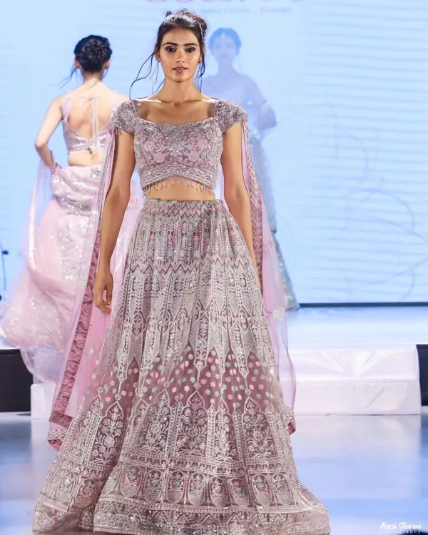 Capturing the elegance of a bridal lehenga on the runway at the "Shaadi by Marriott Bonvoy" event. My focus is on getting a clean, sharp image that showcases the outfit's intricate details and flow.