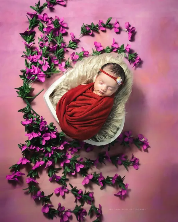 This is the kind of timeless, artistic portrait I love creating for newborns. The focus is entirely on their peaceful sleep and delicate features, wrapped snugly and surrounded by a soft floral arrangement. It’s a beautiful way to remember just how small they once were.